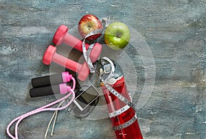 Fruits, dumbbells, a bottle of water, rope, meter, player on a blue background with stains