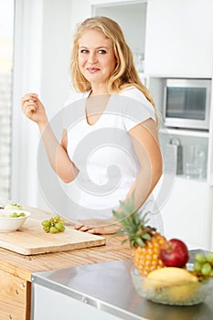 Fruits, eating grapes or woman thinking of a snack, morning meal or healthy lunch diet in home kitchen. Breakfast idea