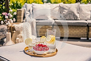 Fruits and glass with water on rattan table on the terrace with