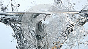 Fruits immersed bubbled water closeup. Raw food making splashes inside glass