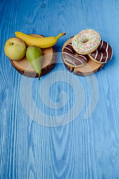 fruits lying on the table againts donuts