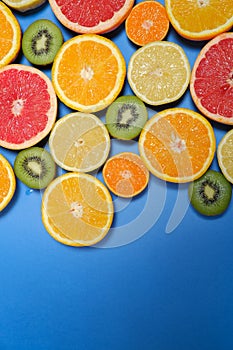 Fruits mix flat lay on blue background, healthy vegetarian organic food, antioxidant detox diet. Fruit background with copy space