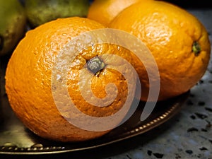 Fruits - oranges kept on a bronze plate.