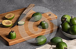 Fruits of ripe feijoa on wooden cutting board. Green berries in cooking process