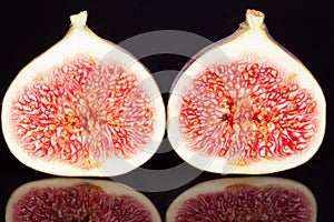 Fruits of sectioned fresh figs on black background