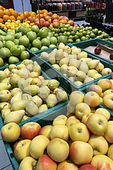 fruits in the supermarket, fresh apples and pears, hypermarket interior