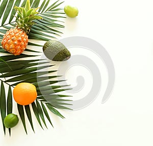 Fruits top view background. tropical green palm leaves branches and fruits pineapples