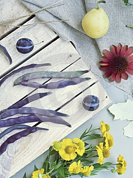 Fruits, vegetables, flowers, leaves on a wooden background