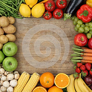Fruits and vegetables forming a frame on a wooden board with cop