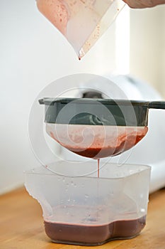 Fruits and vegetables juice filtering juice with a sieve