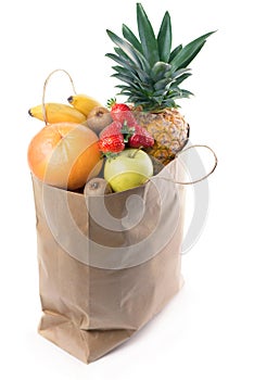 Fruits and vegetables in paper grocery bag isolated over white