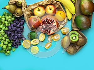 Fruits and vegetables rich in antioxidants, vitamin and fiber on blue background. Zero waste food shopping, eco natural paper bags