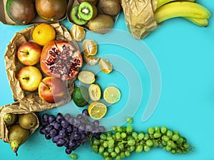 Fruits and vegetables rich in antioxidants, vitamin and fiber on blue background. Zero waste food shopping, eco natural paper bags