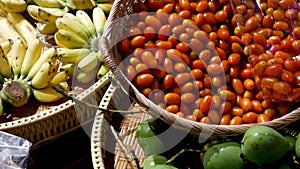 Fruits and vegetables on rustic stall. Assorted fresh ripe fruits and vegetables placed on rustic oriental stall in market. Green