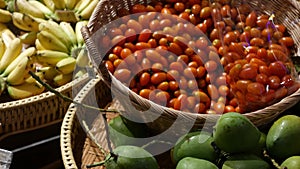 Fruits and vegetables on rustic stall. Assorted fresh ripe fruits and vegetables placed on rustic oriental stall in market. Green