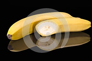 Fruits of yellow bannan on black background, reflection