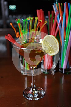 Fruity alcoholic cocktail with straw, lemon and garnish. Colorf