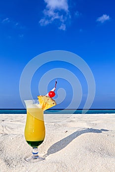 Fruity cocktail is on a beach