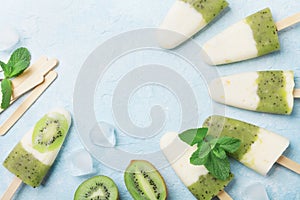 Fruity homemade ice cream or popsicles from kiwi smoothie and yogurt top view. Summer refreshing food.