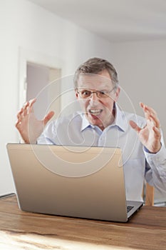 Frustated man looking at laptop