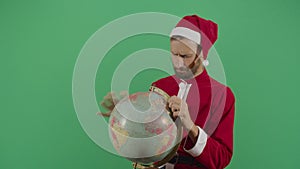 Frustrated adult man santa claus searching the globe