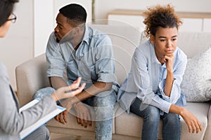 Frustrated Afro Couple Avoiding Eye Contact Sitting At Therapist`s Office