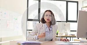 Frustrated angry aggressive business woman boss sitting at the table and looking at camera