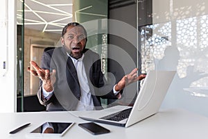 Frustrated angry boss looking at camera, senior gray haired mature man shouting upset, businessman inside office unhappy