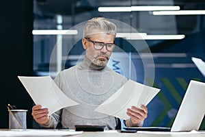 Frustrated and angry businessman with documents, mature gray businessman checking financial reports, boss not satisfied