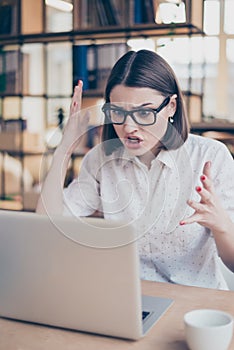 Frustrated angry woman screaming on her laptop