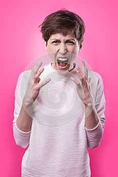 Frustrated and angry woman screaming. Studio shot.