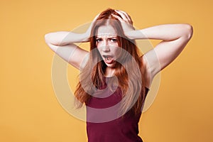 Frustrated angry woman holding her head screaming