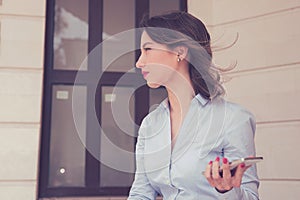 Frustrated annoyed woman with mobile phone standing outside apartment condo