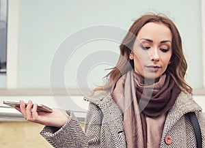 Frustrated annoyed woman with mobile phone standing outside on the street