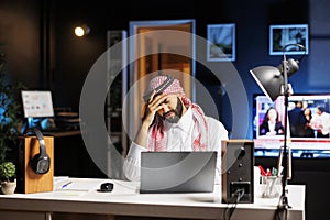 Frustrated Arab man using digital laptop