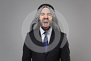 Frustrated arabian muslim businessman in keffiyeh kafiya ring igal agal classic black suit shirt isolated on gray