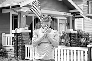 frustrated bearded man realtor selling or renting house with american flag, insurance