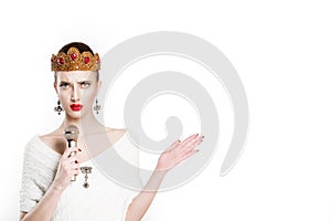 Frustrated beauty queen speaking on microphone gesturing anger with hand isolated white background wall. Angry Girl with golden