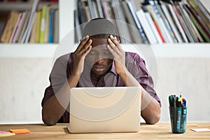 Frustrated black man feeling depressed after fail sitting with l
