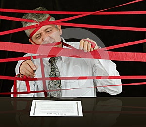 Frustrated business man caught in red tape stopping progress