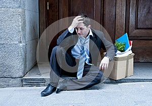 Frustrated business man on street fired with cardboard box
