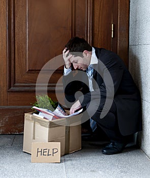 Frustrated business man on street fired carrying cardboard box