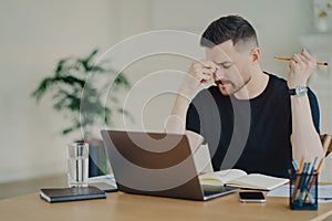Frustrated business person feeling tired while working at his workplace at home or office