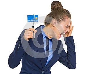 Frustrated business woman cutting credit card