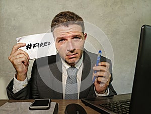 Frustrated businessman desperate at office computer desk holding notepad with the hashtag me too metoo as exploited employee