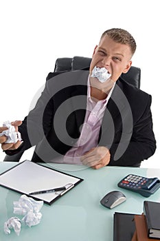 Frustrated businessman with paper in his mouth