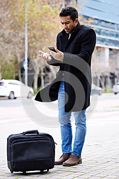 Frustrated businessman, phone and lost in the city with luggage for travel, commute or immigration. Upset or confused