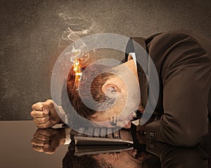 Sad business person`s head catching fire