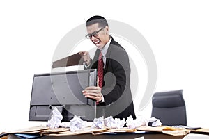 Frustrated businessman sawing his computer