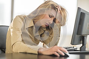 Frustrated Businesswoman Leaning On Computer Desk